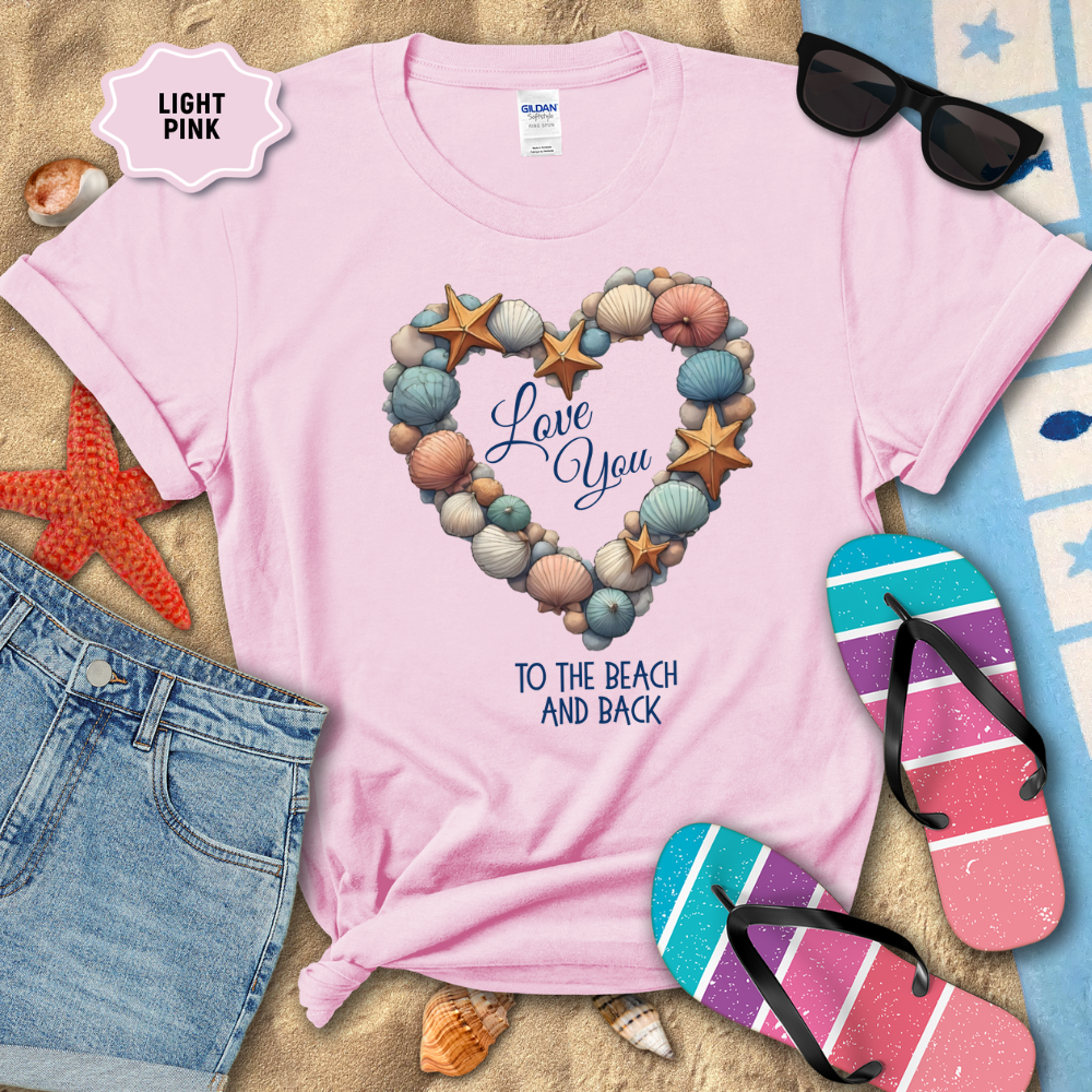 Light pink t-shirt with beach-themed design and accessories on sand