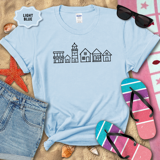 Light blue t-shirt with beach-themed design on sand with flip-flops and sunglasses.