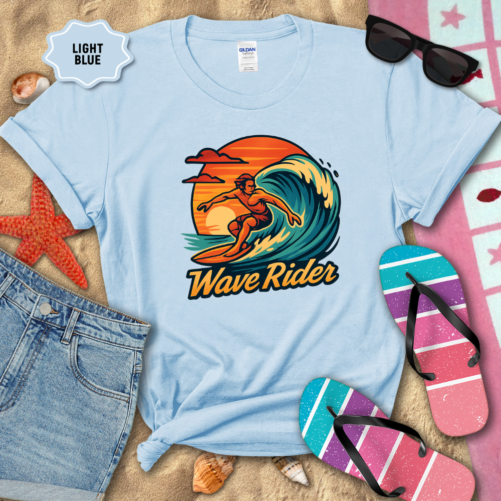 Light blue t-shirt with 'Wave Rider' graphic design on a sandy background with beach accessories.