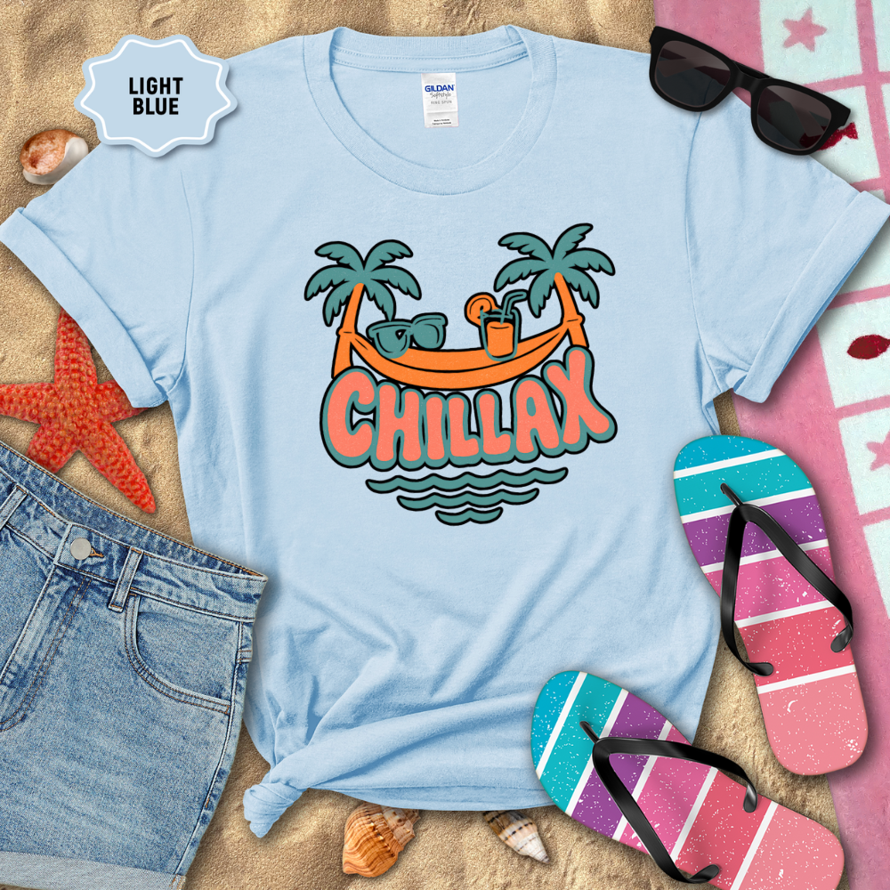 Light blue t-shirt with 'Chillax' graphic on a sandy background with beach accessories.