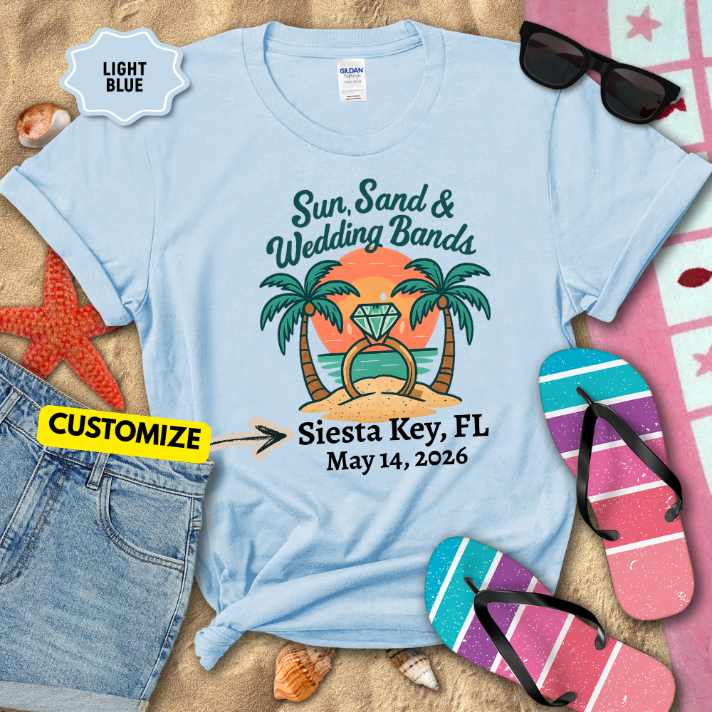 Light blue t-shirt with tropical design and customizable text on a beach-themed background.