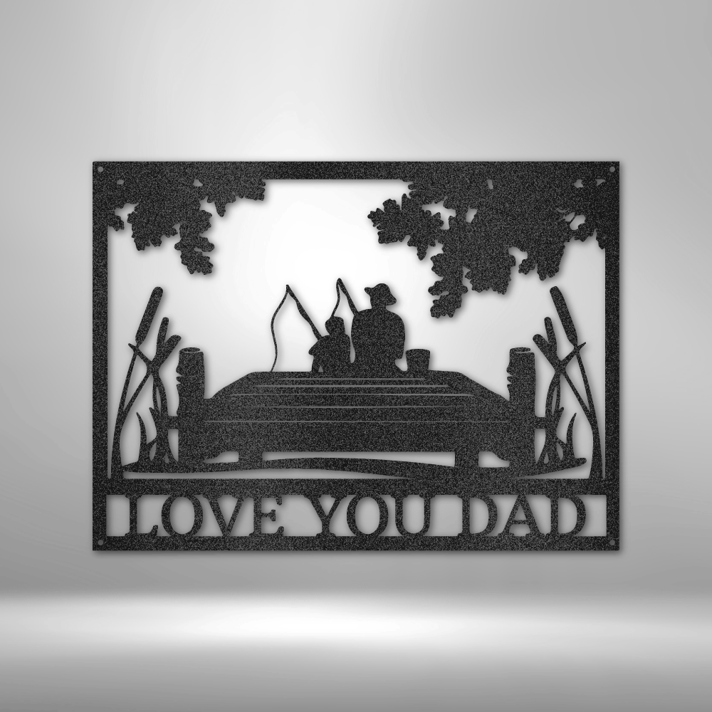Decorative metal wall art with silhouette of a father and child fishing, surrounded by trees and reeds, on a gray background.