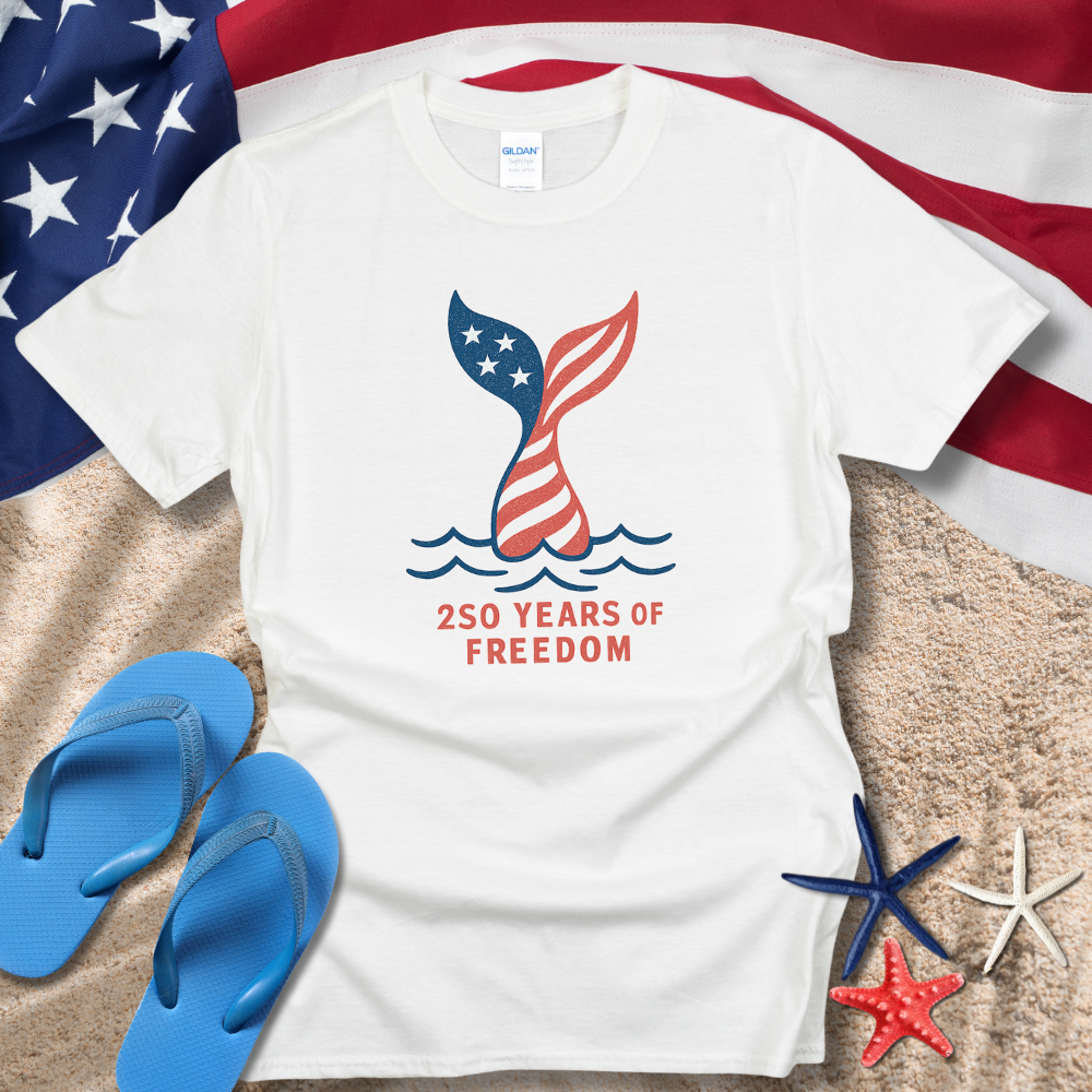 White t-shirt with '250 Years of Freedom' design on a beach setting with American flag, flip-flops, and starfish.