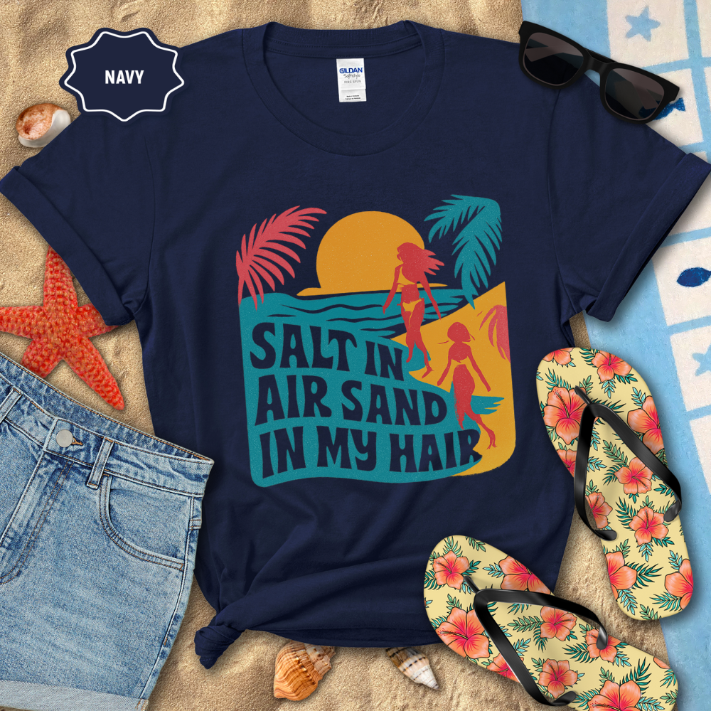 Navy t-shirt with beach-themed design and flip-flops on a sandy background