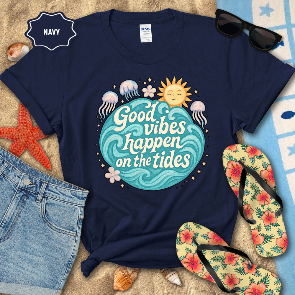 Navy t-shirt with 'Good vibes happen on the tides' design, surrounded by beach accessories.