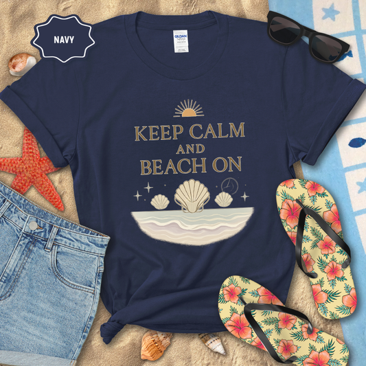 Navy t-shirt with 'Keep Calm and Beach On' design on a sandy background with flip-flops and sunglasses.
