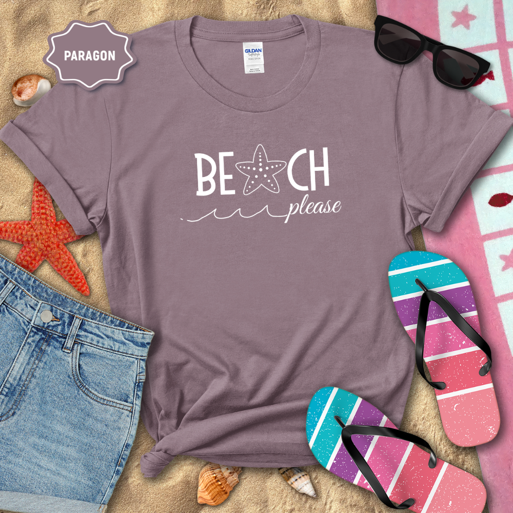 Purple t-shirt with 'Beach Please' text on a sandy background with beach accessories.