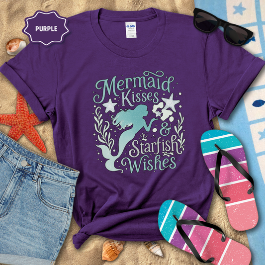 Purple t-shirt with mermaid design and text, surrounded by beach accessories.