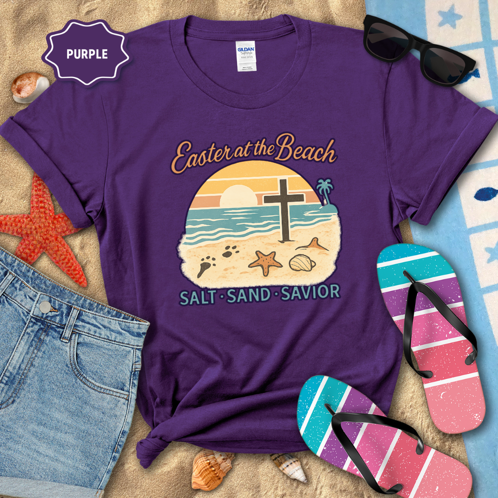 Purple t-shirt with beach-themed design and text, surrounded by flip-flops and sunglasses on a beach-themed background.