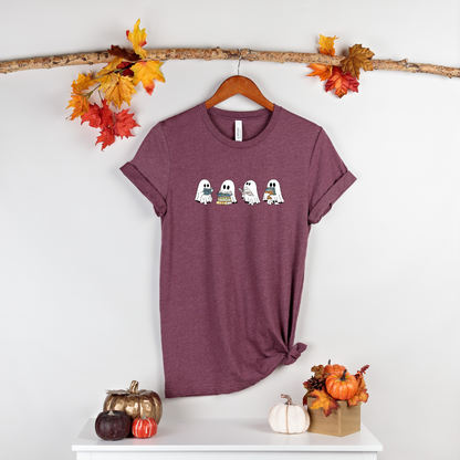 Maroon Halloween t-shirt with four cartoon ghosts holding books and wearing cozy fall scarves.

