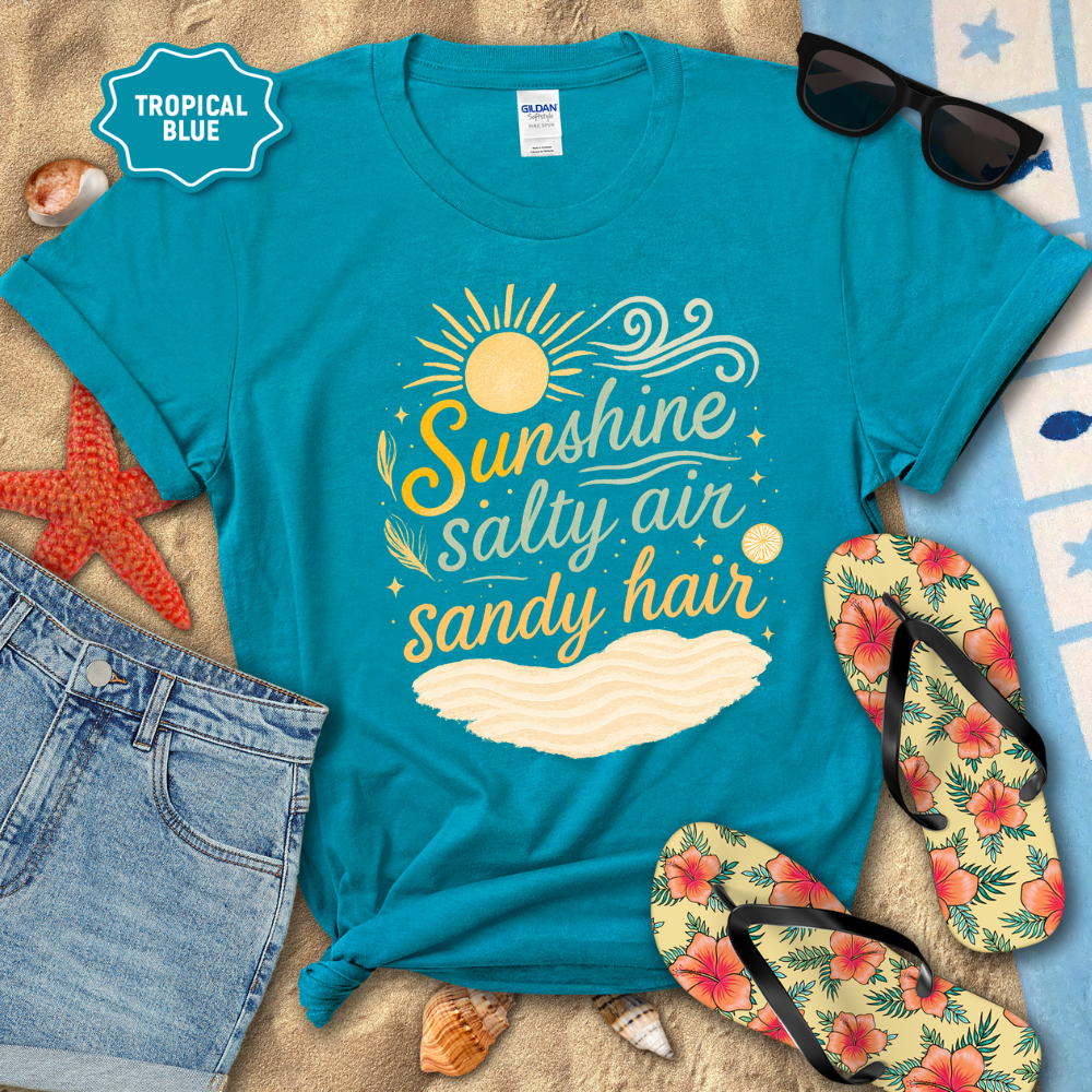 Blue t-shirt with 'Sunshine, Salty Air, Sandy Hair' design on a beach-themed background with sunglasses, flip-flops, and starfish.