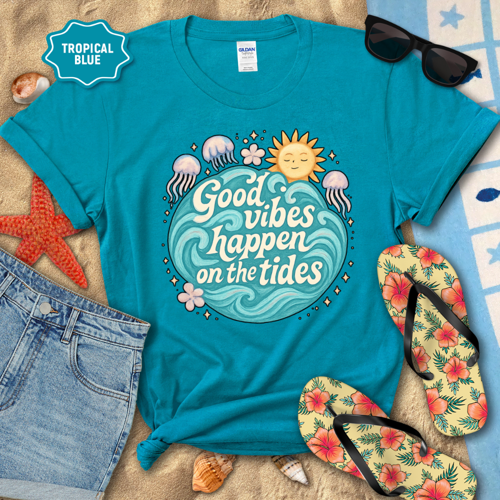 Turquoise t-shirt with 'Good vibes happen on the tides' design, surrounded by beach accessories.