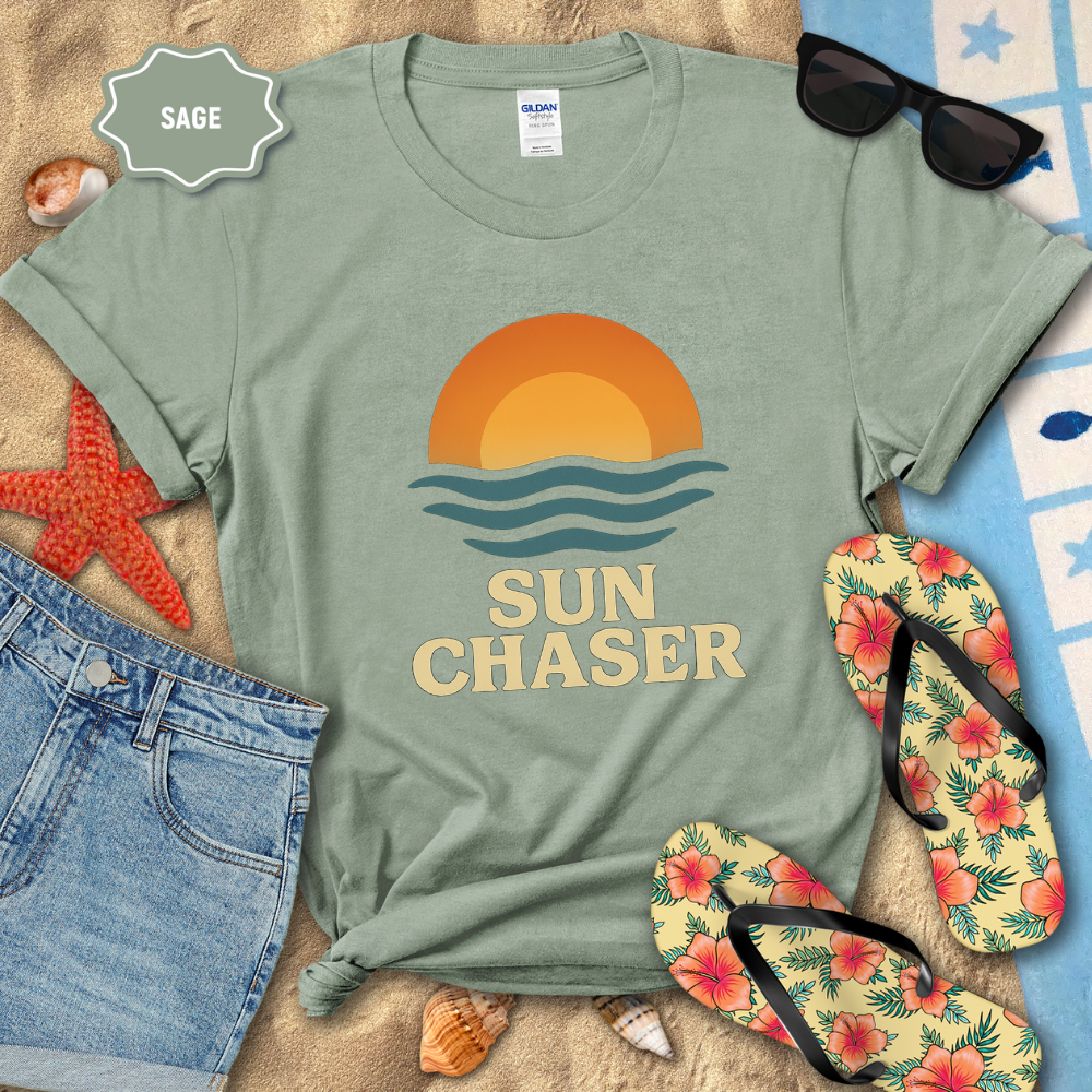 Sage green t-shirt with 'Sun Chaser' design on a beach setting with sunglasses, flip-flops, and starfish.