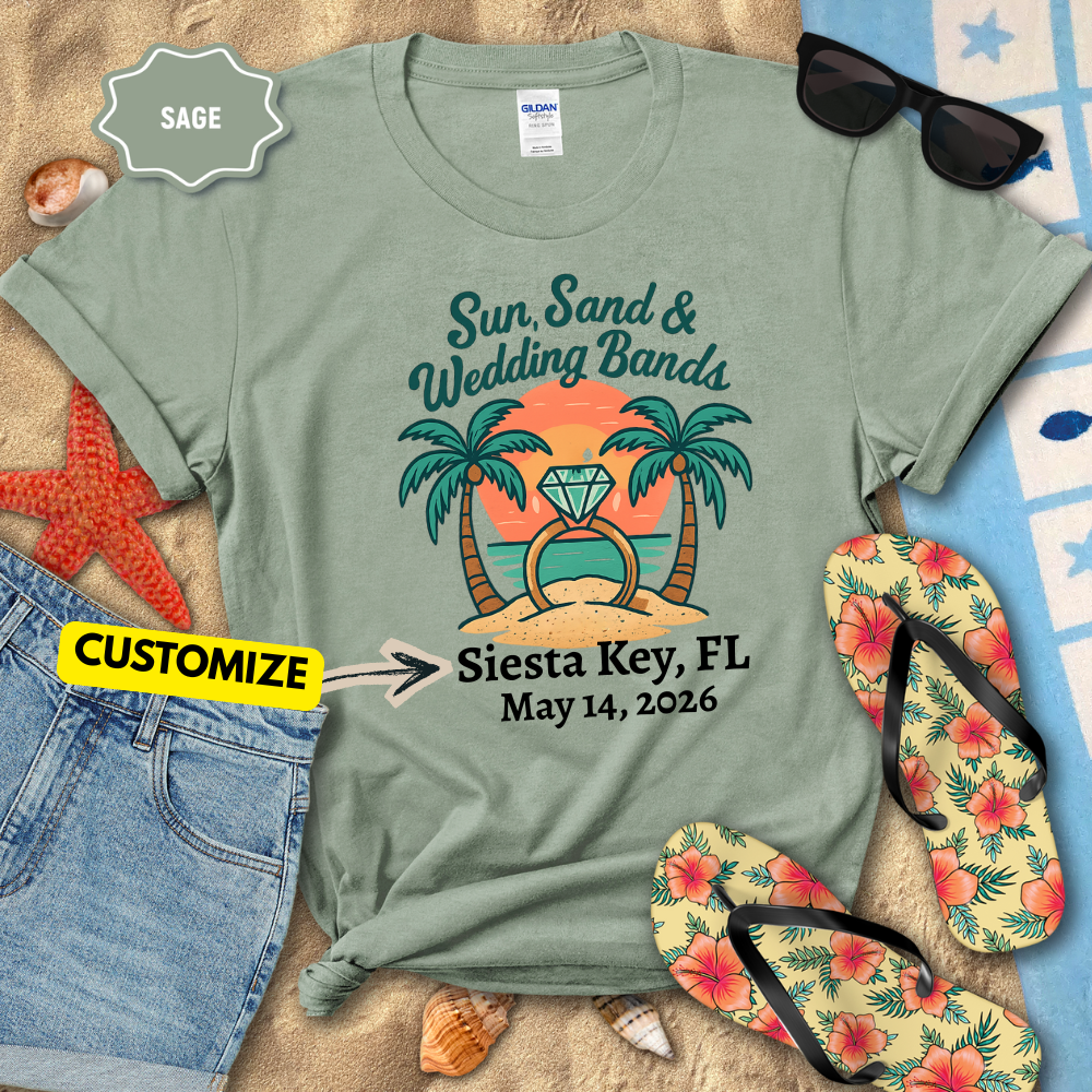 Sage green t-shirt with 'Sun, Sand & Wedding Bands' design on a sandy background with flip-flops and sunglasses.