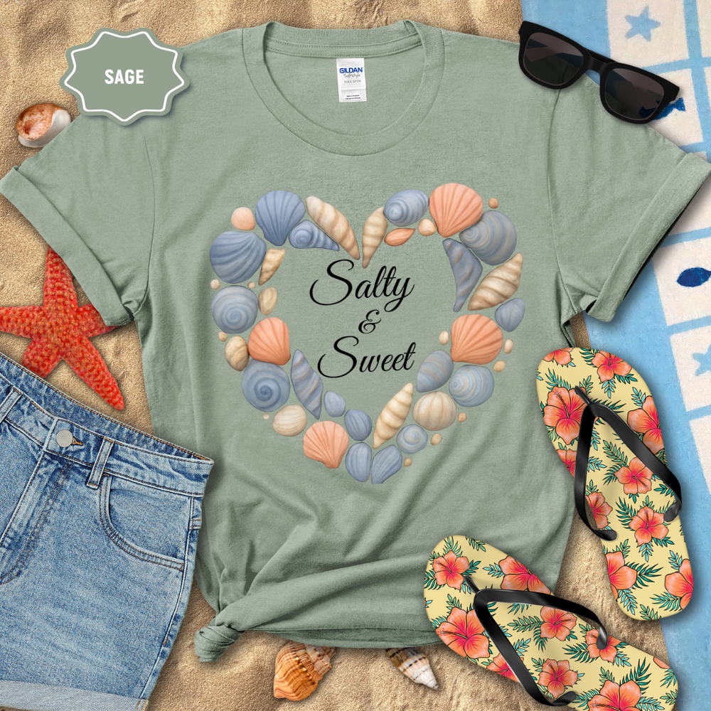Sage green t-shirt with shell design and 'Salty & Sweet' text, surrounded by beach accessories.