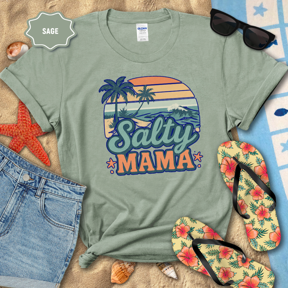 Sage green t-shirt with 'Salty Mama' design on a beach-themed background with sunglasses, flip-flops, and starfish.
