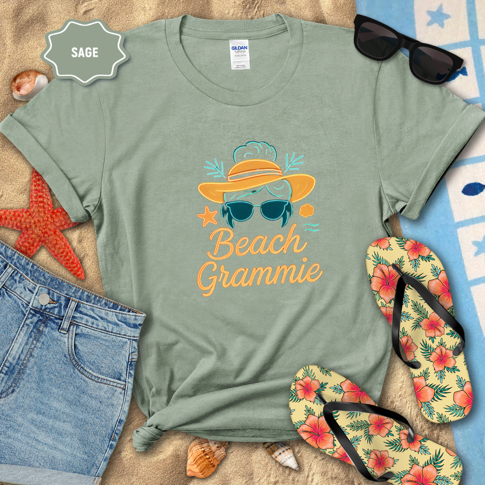 Sage green t-shirt with 'Beach Grammie' design on a sandy background with flip-flops and sunglasses.