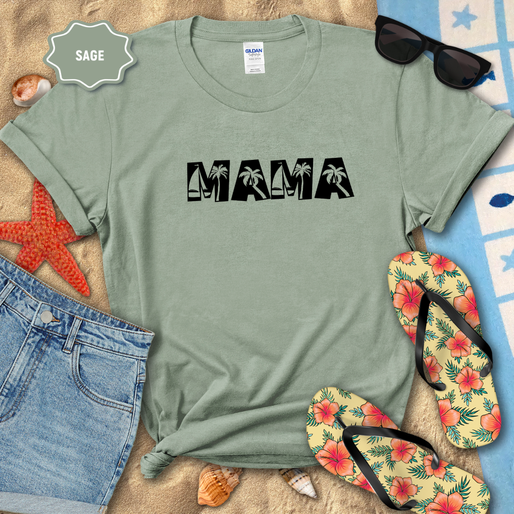 Sage green t-shirt with 'MAMA' print on a beach setting with sunglasses, flip-flops, and beach accessories.