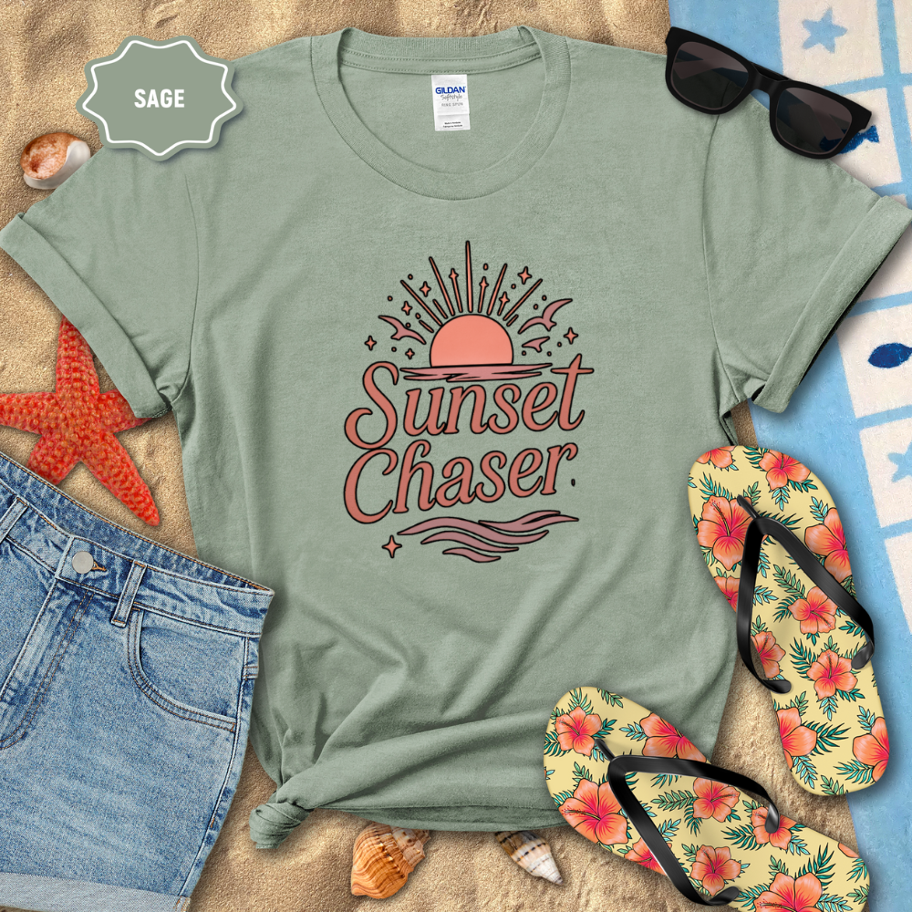 Sage green t-shirt with 'Sunset Chaser' design on a beach setting with sunglasses, flip-flops, and starfish.
