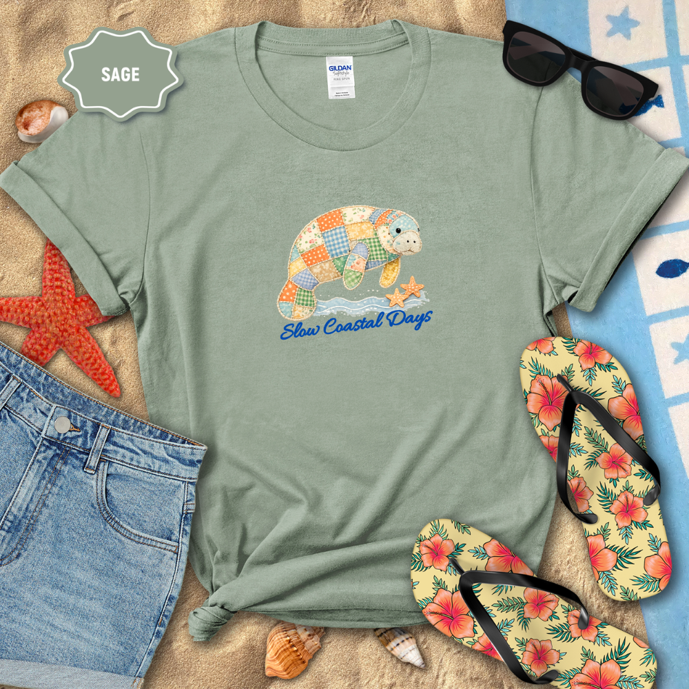 Sage green t-shirt with a patchwork sea turtle design and 'Sole Coastal Days' text, surrounded by beach accessories.
