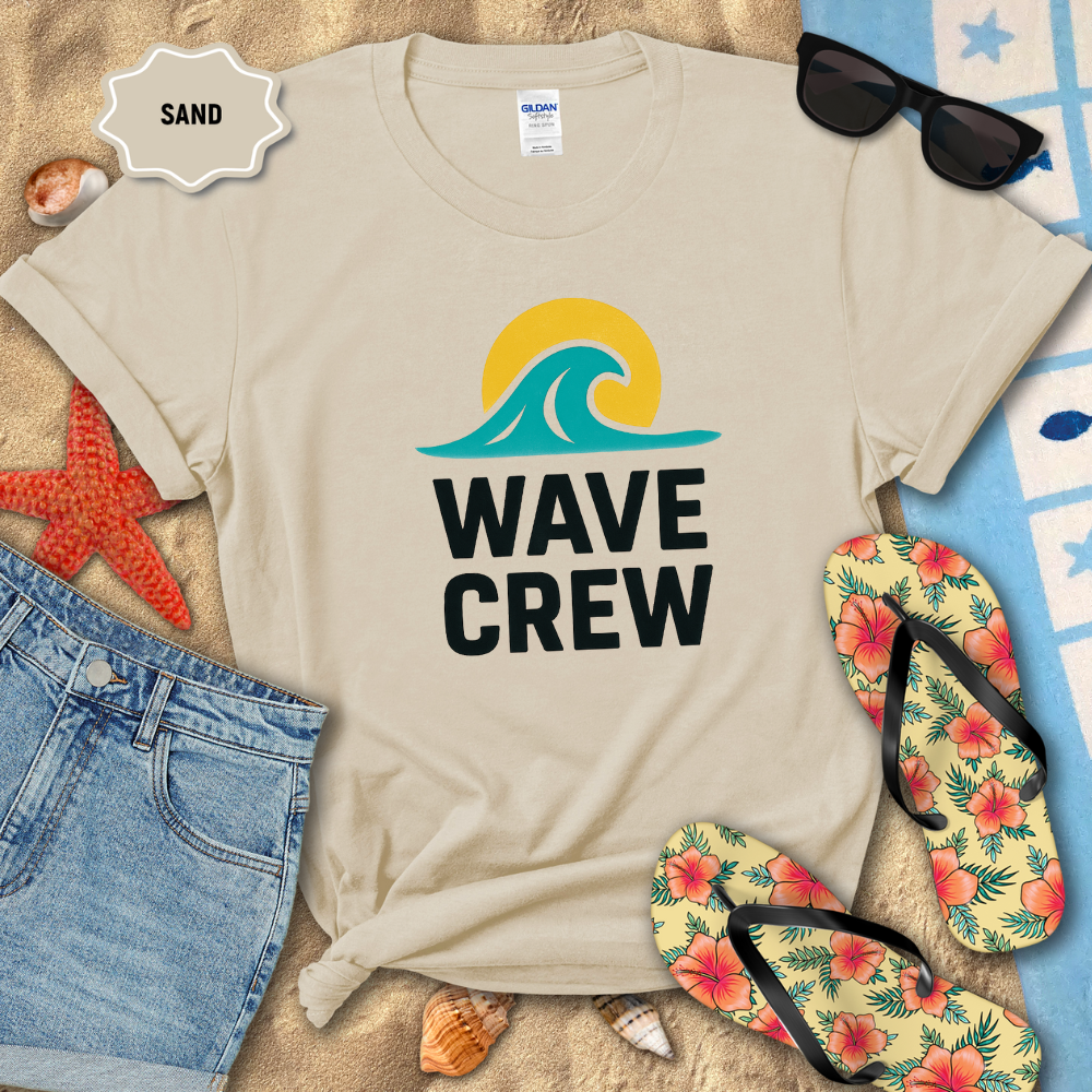Beige t-shirt with 'WAVE CREW' design on a sandy background with beach accessories.