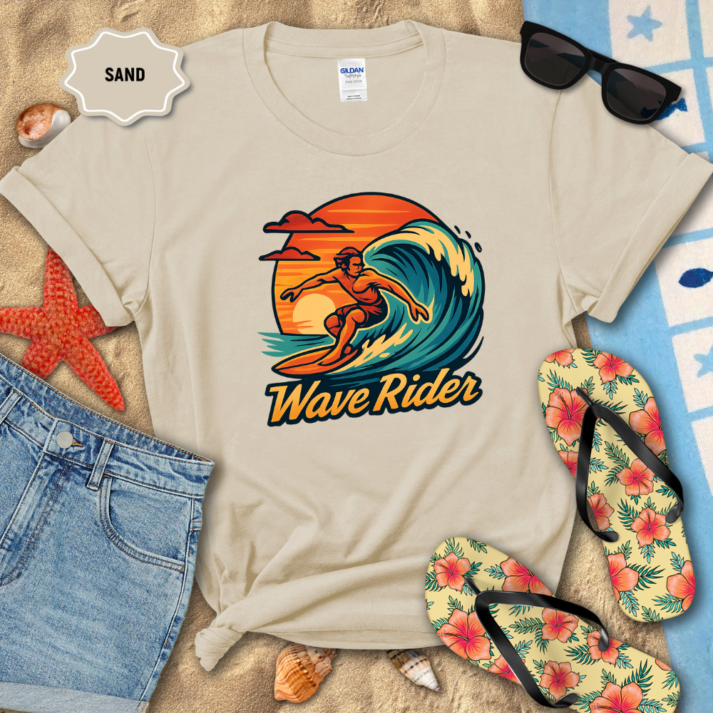 Beige t-shirt with 'Wave Rider' design on a sandy background with beach accessories.