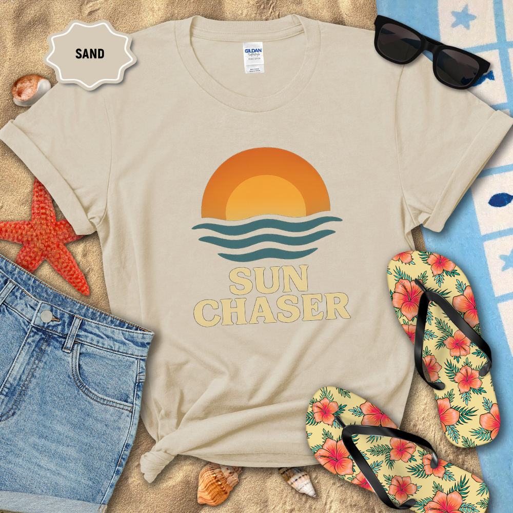 Beige t-shirt with 'Sun Chaser' design on a sandy background with flip-flops and sunglasses.