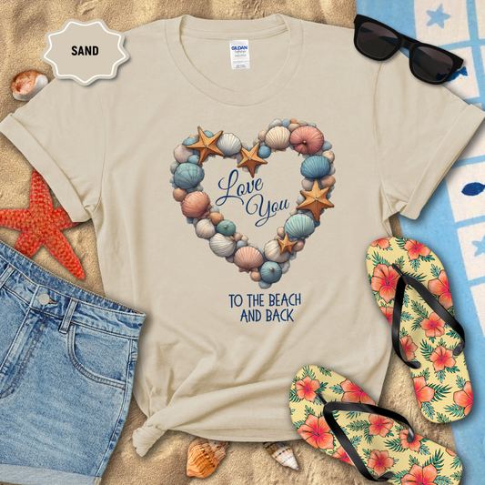 Beige t-shirt with beach-themed design on sand with sunglasses, flip-flops, and starfish.