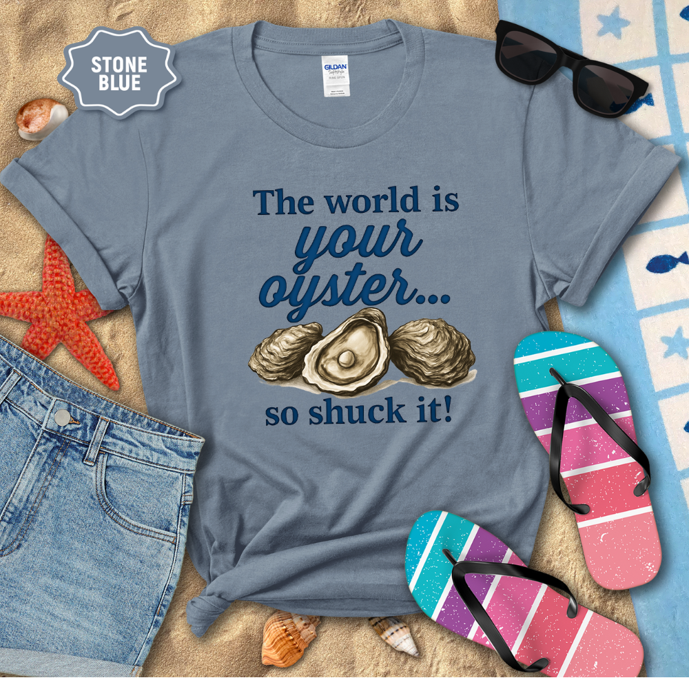 Blue t-shirt with oyster graphic and text, sunglasses, flip-flops, and denim shorts on a sandy background.