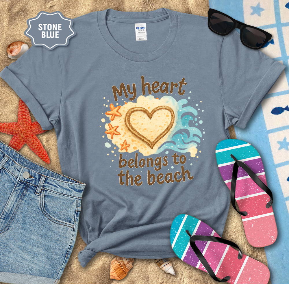 Stone blue t-shirt with beach-themed design and accessories on a sandy background