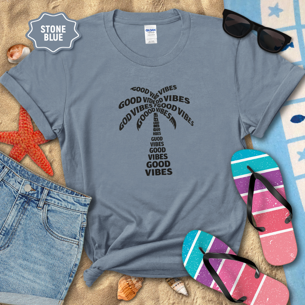 Stone blue t-shirt with 'Good Vibes' text, sunglasses, and flip-flops on a sandy background