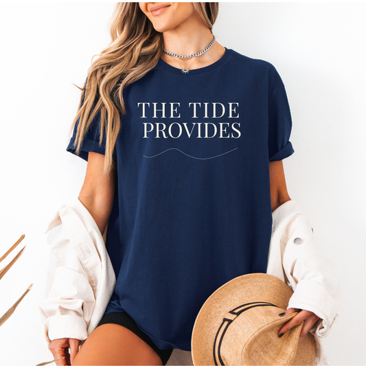 Person wearing a navy blue t-shirt with 'THE TIDE PROVIDES' text, holding a hat.