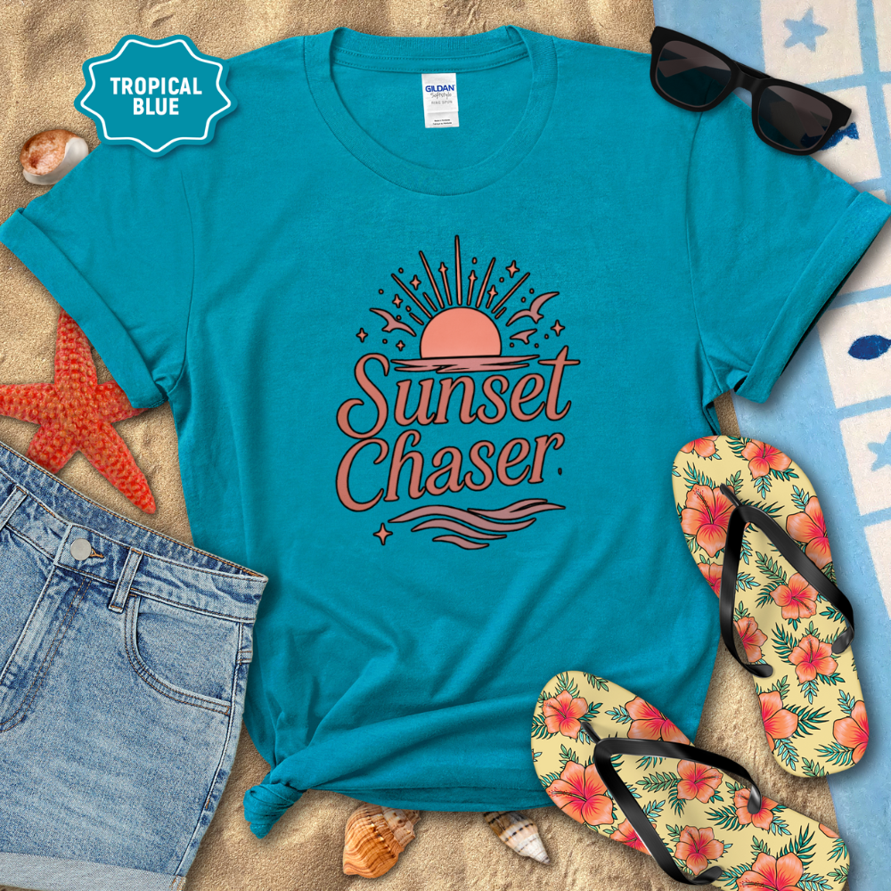 Blue t-shirt with 'Sunset Chaser' design on a beach setting with sunglasses, flip-flops, and starfish.