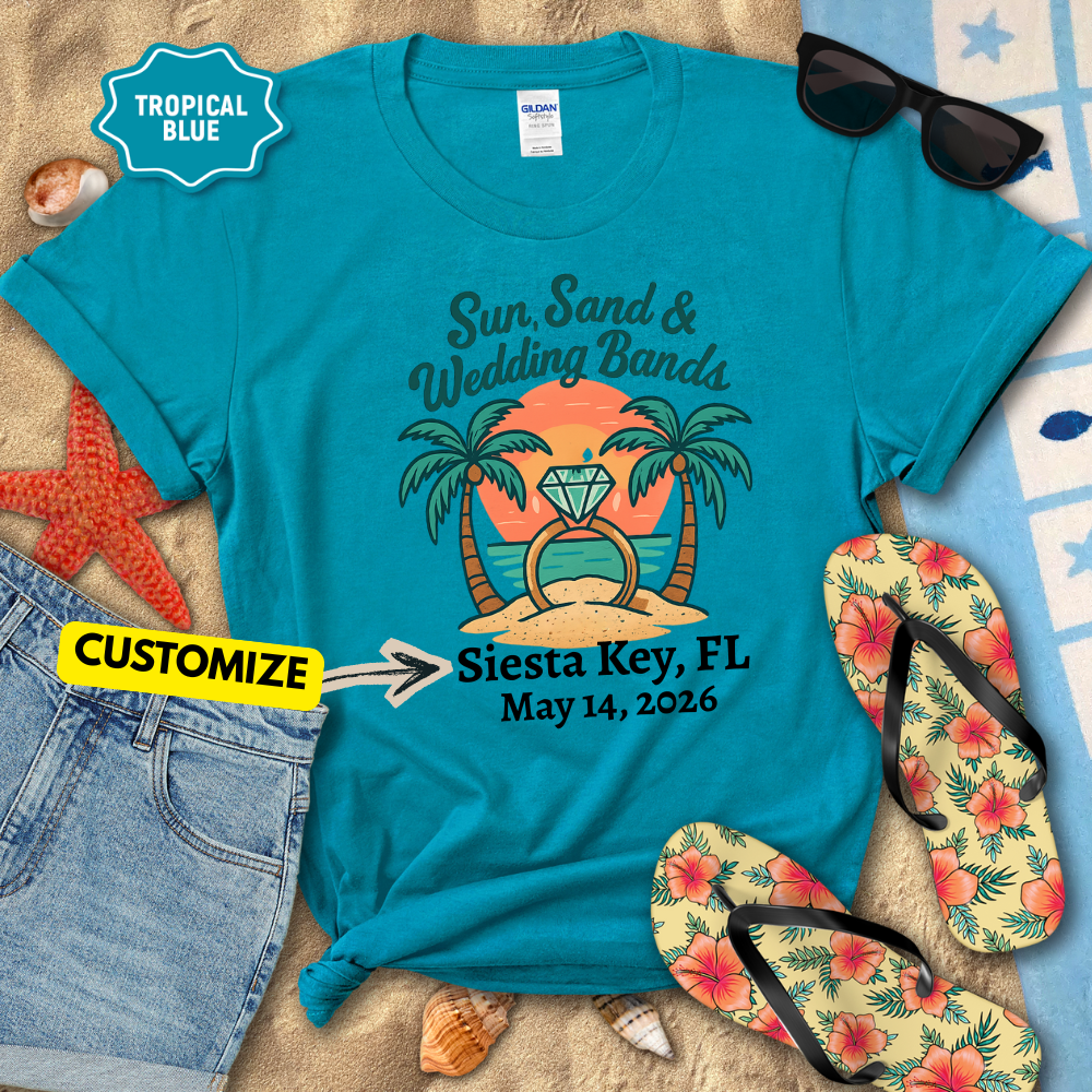 Blue t-shirt with tropical design and customizable text on a beach setting