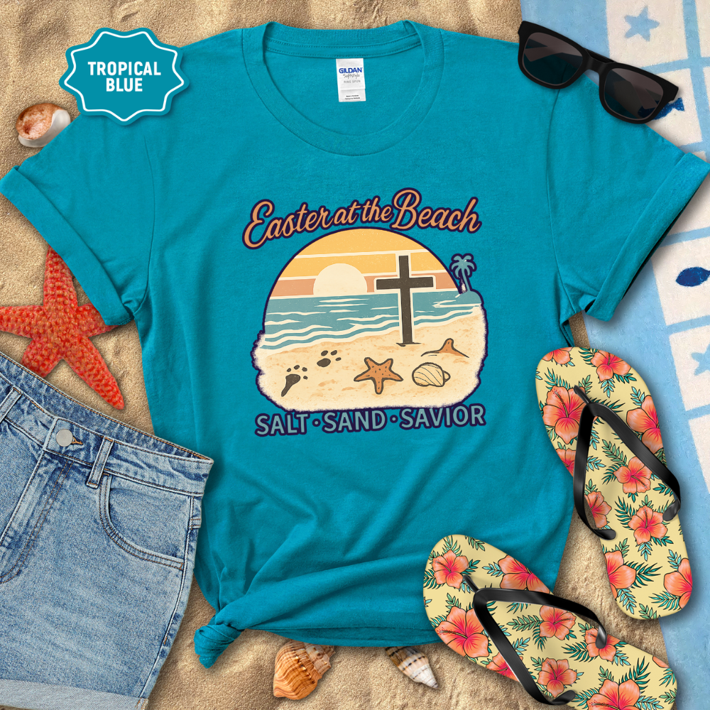 Blue t-shirt with 'Easter at the Beach' design on a sandy background with flip-flops and sunglasses.
