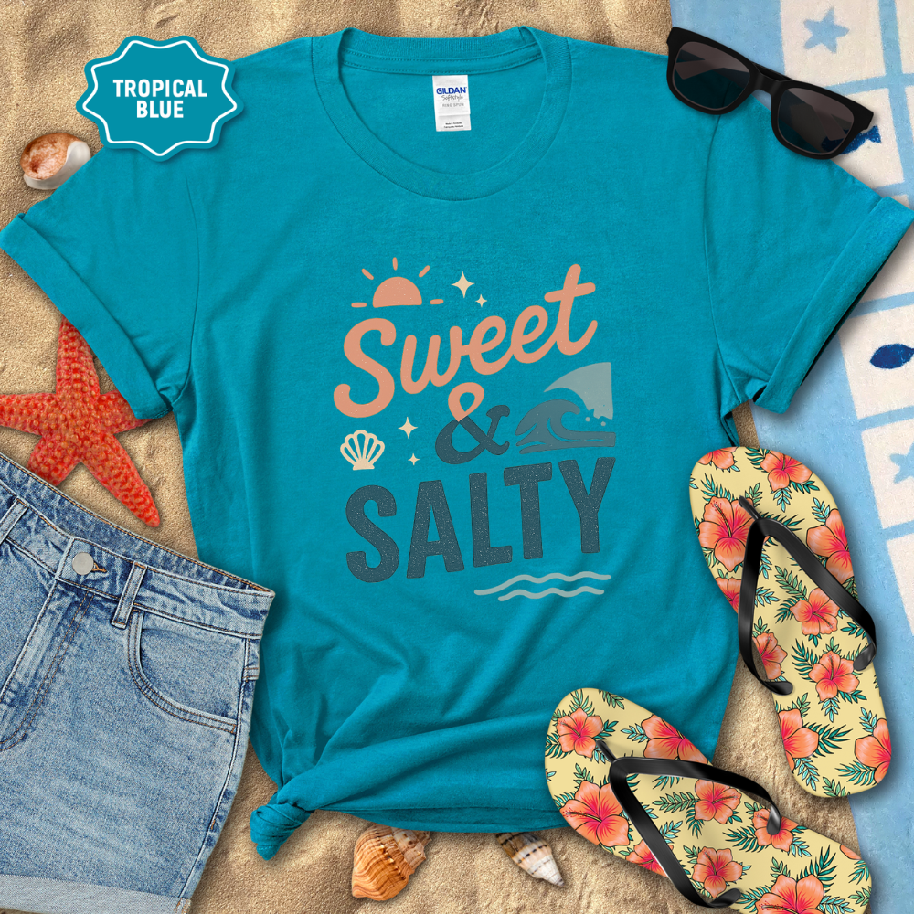 Blue t-shirt with 'Sweet & Salty' text on a beach setting with sunglasses, flip-flops, and starfish.
