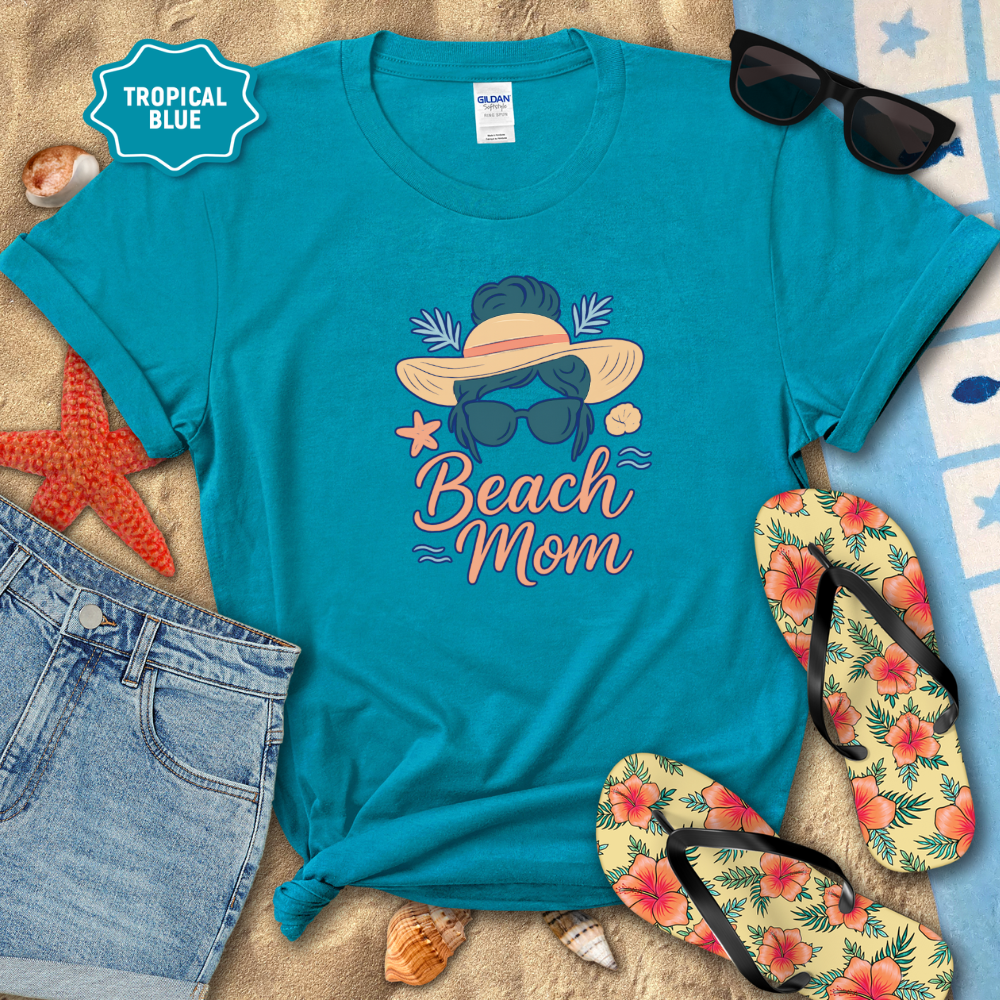 Blue t-shirt with 'Beach Mom' design on a sandy background with flip-flops and sunglasses.