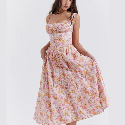 
Woman wearing a pink floral summer midi dress with fitted bodice