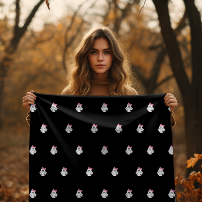 Woman holding a black fabric with ghost patterns in an autumn forest