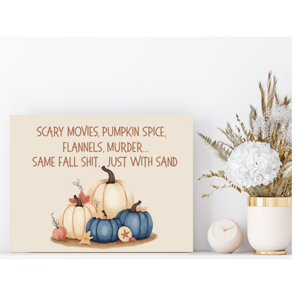 Decorative sign with pumpkins and text next to a vase with flowers on a white background