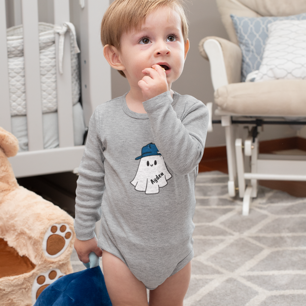 Child wearing a gray onesie with a ghost design in a home setting