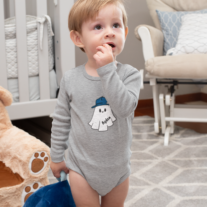 Child wearing a gray onesie with a ghost design in a home setting