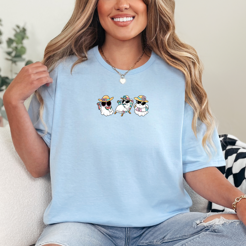 Woman wearing a light blue t-shirt with cartoon designs, sitting on a couch.