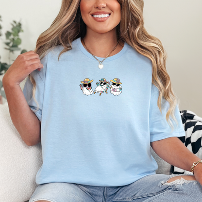 Woman wearing a light blue t-shirt with cartoon designs, sitting on a couch.