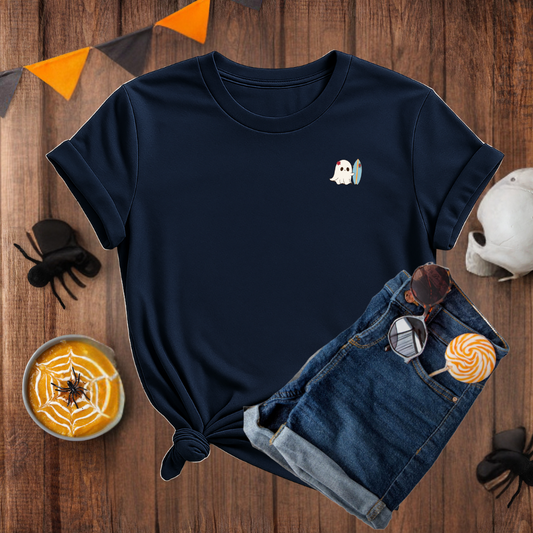 Navy blue t-shirt with ghost design on a wooden surface with Halloween decorations.