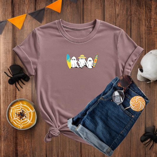 Purple t-shirt with Halloween-themed design on a wooden surface with accessories.