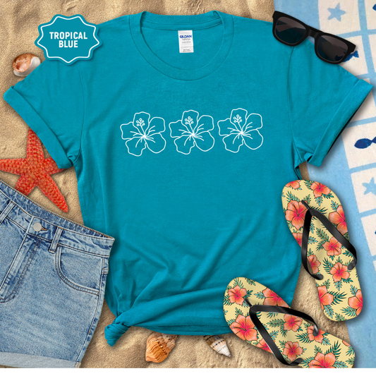 Blue t-shirt with floral designs, sunglasses, and flip-flops on a beach-themed background