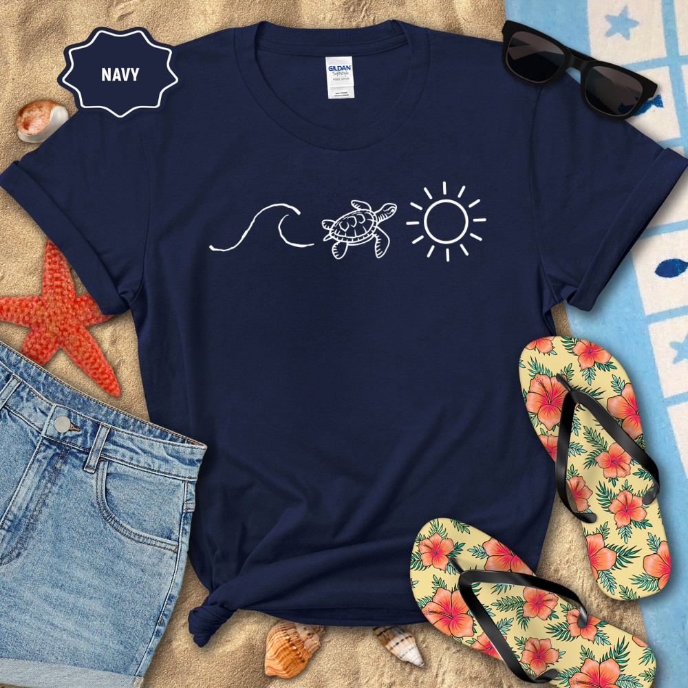 Navy t-shirt with turtle, wave, and sun design on a beach-themed background with flip-flops and sunglasses.