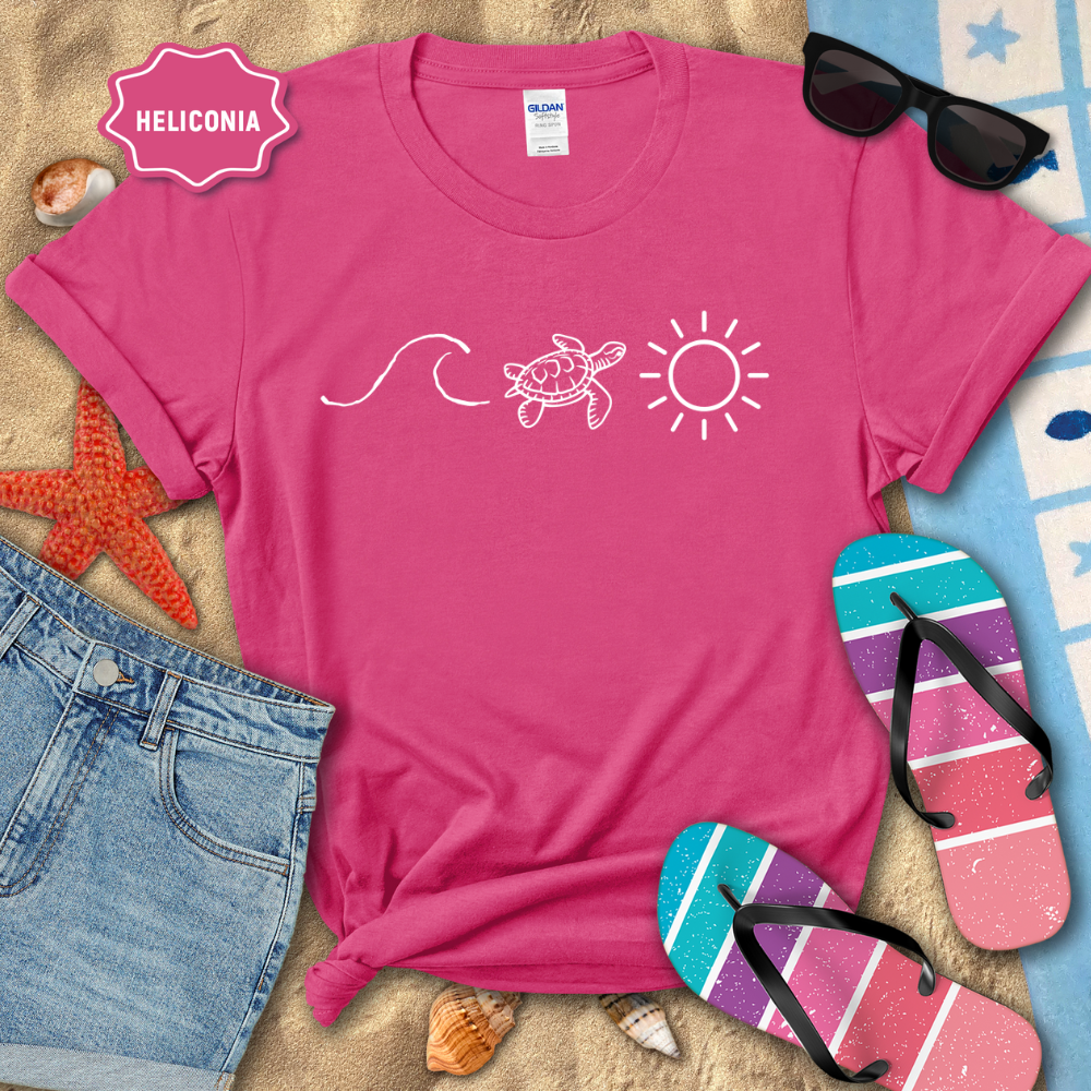 Pink t-shirt with beach-themed design on sand with sunglasses, flip-flops, and starfish.