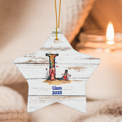 Star-shaped wooden ornament with 'Liam 2025' text, hanging against a blurred candlelit background.